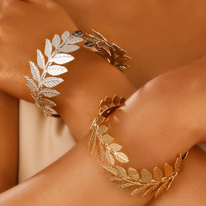 Greek style gold and silver leaf arm cuffs with intricate hollowed branch textures