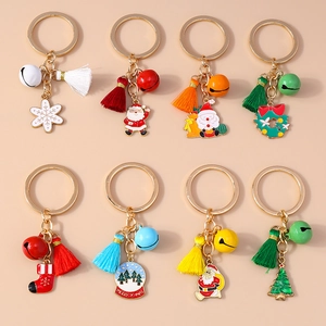 Detailed flat lay of 8 Christmas keychains with tassels, bells and enamel charms