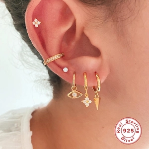 Elegant 925 sterling silver clover earrings set with gold finish on model ear