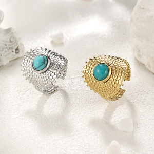 Detailed shot of gold and silver plated stainless steel rings with turquoise inlay