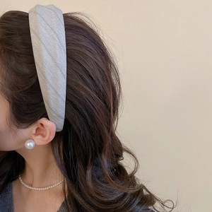Detail of grey herringbone fabric headband shown on a model for a vintage elegant look