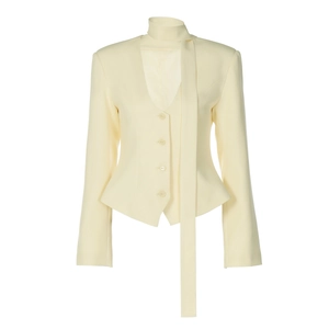 Detailed close-up of cream blazer featuring unique scarf lapel and four-button waist design