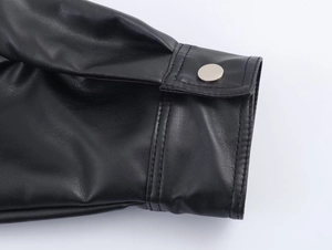 Detail of black leather jacket cuff featuring silver button and precision stitching
