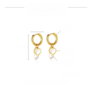 Detail view of heart-shaped shell and freshwater pearl drop earrings in gold steel
