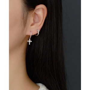 Close-up of S925 sterling silver hoop earrings with a sparkling zircon cross pendant