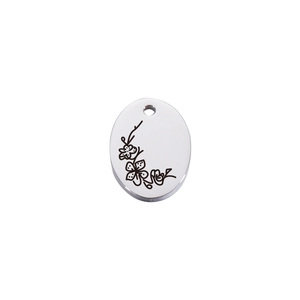 Detailed macro view of an oval stainless steel pendant with delicate flower engraving