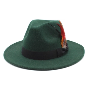 Deep green fedora wool hat with black ribbon and colorful feather decoration on white background
