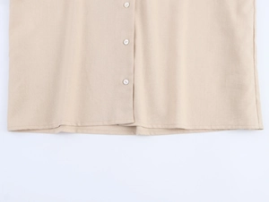 Close-up of beige cotton linen blouse featuring white buttons and textured fabric