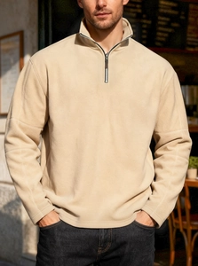 Close-up of beige men's half-zip fleece sweatshirt with cozy stand-up collar texture
