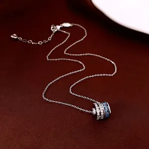 Luxury zircon round cylinder necklace with blue gemstone on red velvet background