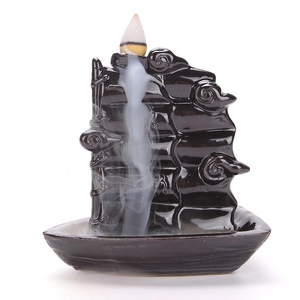 Ceramic boat-shaped backflow incense burner with smoke flowing down like a waterfall
