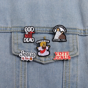 Detail of enamel pins featuring religious humor on light blue denim jacket pocket