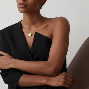 Polished 18K gold-plated heart pendant necklace on model with black minimalist top