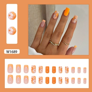 Faux ongles orange et rose avec motifs marguerites et design French manucure