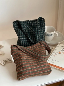Close-up of vintage plaid tweed tote bags with texture detail and side brand label