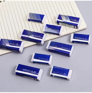 Close-up of 2B plastic erasers with blue paper sleeves on a ruled notebook page