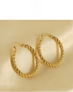 Detailed view of 18K gold plated twisted hoop earrings on an elegant satin background