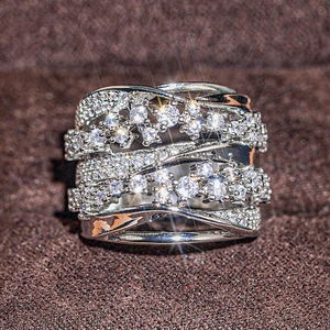 Macro shot of wide silver interwoven ring with clustered zircon stones on velvet