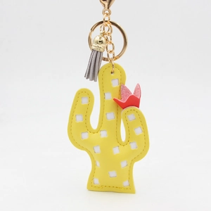 Détail du porte-clés cactus jaune en cuir PU avec fleur rouge, pompon gris et crochet