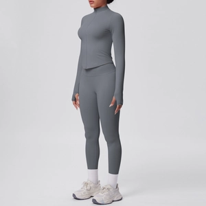 Dettaglio della giacca da yoga grigia con zip e leggings sportivi a vita alta