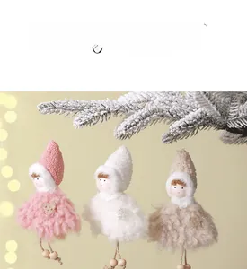 Gros plan de trois poupées anges de Noël en peluche sur des branches enneigées
