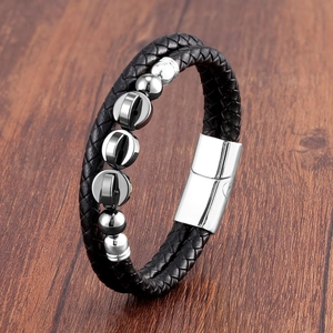 Detail of double-layer black braided leather bracelet with silver metal beads and magnetic clasp