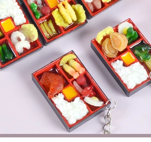 Macro detail of miniature Japanese bento box keychains with realistic food models
