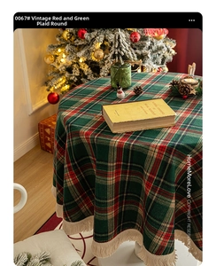 Detail of red and green plaid round tablecloth with beige fringe tassels and soft textures