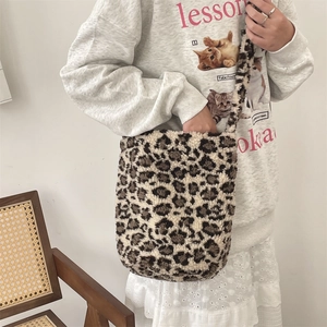 Leopard print faux fur bucket bag shown on model with plush texture and soft strap