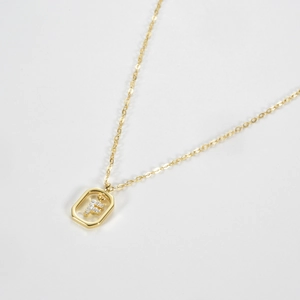 Macro detail of gold plated S925 silver necklace with letter F pendant in octagonal frame