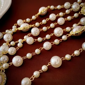 French style multi-layer pearl necklace with gold chain on brown velvet background