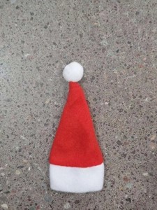 Close-up of red and white Christmas hat cutlery holder on a textured gray background