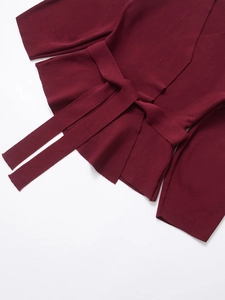 Close-up of dark red wrap-style knit sweater with tie-waist and ribbed texture details