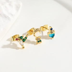 Detail of three micro-inset zircon stud earrings featuring bird and character designs