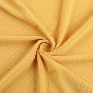 Macro texture of yellow mesh knit fabric showing breathable pore structure and soft drape