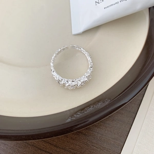 Dettaglio della texture irregolare fusa e della finitura argento lucido su questo anello