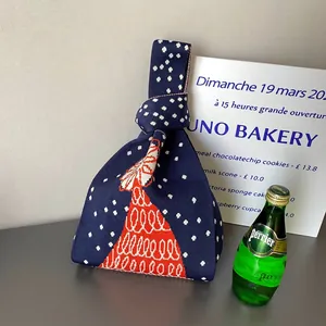 Détail du sac à main en tricot bleu marine à pois blancs et motifs festifs