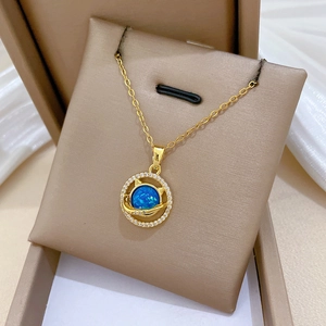 Detailed macro of gold cat planet pendant with blue opal and sparkling crystals