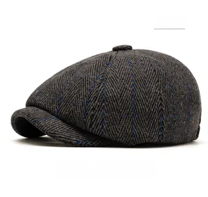 Gros plan d'une casquette gavroche grise à chevrons avec de fins carreaux bleus