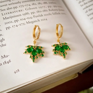 Elegant gold plated maple leaf hoop earrings featuring vibrant green cubic zirconia stones