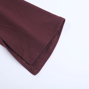 Detailed close-up of burgundy knitted fabric texture and hem craftsmanship on halter top