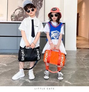 Close-up of sporty cylindrical nylon cross-body bags for kids in orange and black