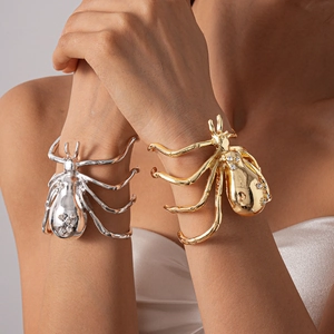 Detailed view of gold and silver spider-shaped open bangles with diamond accents on model