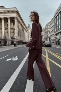 Détail d'un tailleur pantalon bordeaux pour femme avec veste ajustée et pantalon