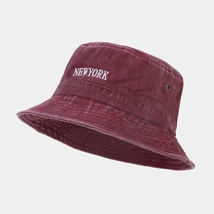 Detail of New York embroidery and metal eyelets on a burgundy washed cotton bucket hat