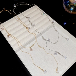 Gros plan de colliers fins en or et argent avec zircons et perles multicouches