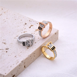 Three buckle-shaped rings in gold, silver, and rose gold with black enamel and zircons