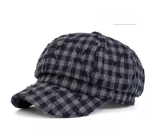 Dettaglio del cappello newsboy a quadri blu navy con bordi sfrangiati e trama vintage