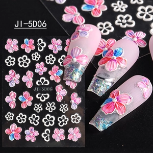 Detailed 5D embossed nail stickers featuring pink and blue flowers on manicure display