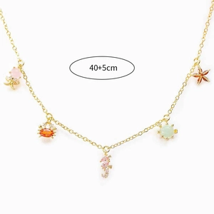 Detail view of gold ocean animal charms necklace with seahorse and starfish pendants